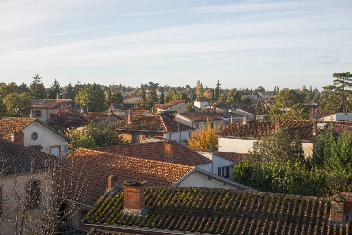 Toitures en tuiles mécaniques d’un lotissement pavillonnaire de Colomiers sous le ciel du Sud-Ouest